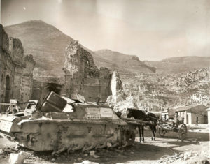 Cassino 1944-45: un carro armato semidistrutto abbandonato e un carretto con cavallo davanti ai resti della chiesa di S. Antonio.